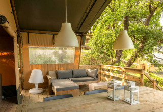 Tenda safari elegante con area relax su terrazza in legno al Camping Centro Vacanze San Marino, Italia.