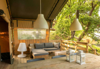 Tenda safari elegante con area relax su terrazza in legno al Camping Centro Vacanze San Marino, Italia.