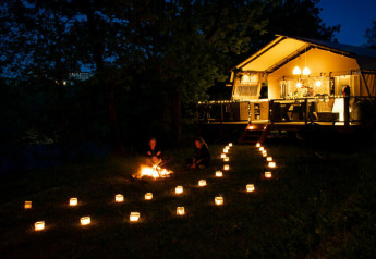 Night view of Desert Lodge safari tent at Camping Centro Vacanze San Marino, Italy, lit by lanterns.
