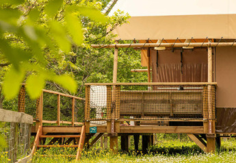 Tenda safari Desert Lodge con servizi igienici al Camping Centro Vacanze San Marino, Italia, immersa nel verde.