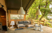 Tienda safari Desert Lodge con terraza de madera y zona de estar en Camping Centro Vacanze San Marino, Italia.