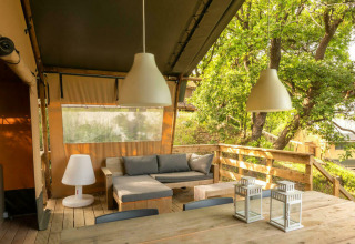 Tienda safari Desert Lodge con terraza de madera y zona de estar en Camping Centro Vacanze San Marino, Italia.