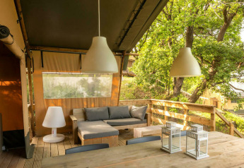 Desert Lodge safari tent with wooden deck, dining area and lounge at Camping Centro Vacanze San Marino, Italy.