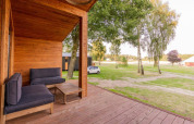 Terraza de madera en Lakehouse con sofás y vistas a la naturaleza en Wilsumer Berge, Alemania.