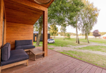 Wooden deck of Lakehouse with modern seating and scenic view at Wilsumer Berge, Germany.