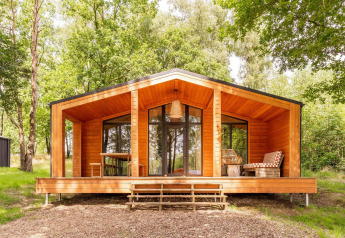 Scandinavische houten lodge bij Forresthouse Scandi in Wilsumer Berge, Duitsland, omringd door natuur.