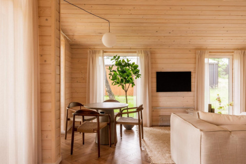 Licht houten interieur van Forresthouse Scandi lodge bij Wilsumer Berge in Duitsland met gezellige zithoek.