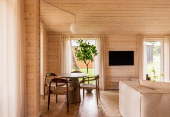 Licht houten interieur van lodge Forresthouse Scandi in Wilsumer Berge, Duitsland, met knusse zithoek.
