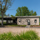 Forest Lodge med privat sauna og boblebad på feriestedet 't Schuttenbelt i Holland omgivet af træer.