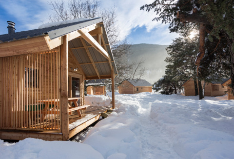 Cabañas de madera rodeadas de nieve en Les chalets Huttopia de Bourg-St-Maurice, Francia en invierno