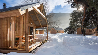 Cabañas de madera rodeadas de nieve en Les chalets Huttopia de Bourg-St-Maurice, Francia en invierno