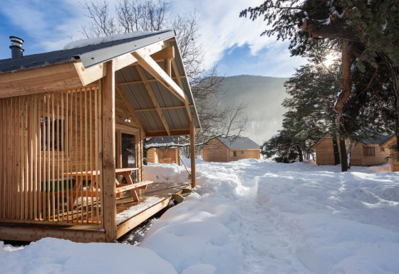 Cabañas de madera rodeadas de nieve en Les chalets Huttopia de Bourg-St-Maurice, Francia en invierno