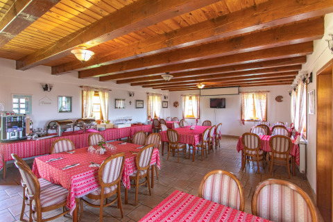 Dining area with wooden beams and red tablecloths at Boutique Camping Heart of Nature in Karlovac, Croatia.