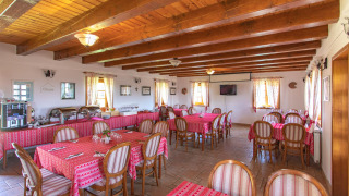 Comedor con vigas de madera y manteles rojos en Boutique Camping Heart of Nature en Karlovac, Croacia.