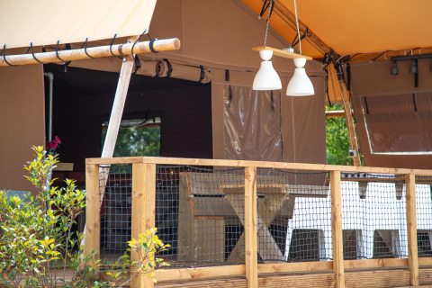 Tienda safari Desert Lodge en Boutique Camping Heart of Nature, Croacia, con terraza de madera y lámparas.