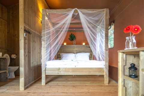 Interno della tenda safari Desert Lodge al Boutique Camping Heart of Nature in Croazia con letto in legno.