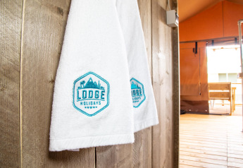 Toallas blancas con el logo 'Lodge Holidays' en una tienda safari de Desert Lodge, Boutique Camping Heart of Nature, Croacia.