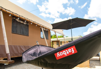 Vista exterior de la tienda safari Desert Lodge con silla Fatboy en Boutique Camping Heart of Nature, Croacia.