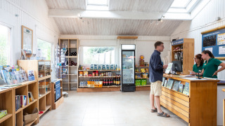 Rezeption und Laden von Huttopia Noirmoutier mit Gästen und Personal in Pays de la Loire, Frankreich.