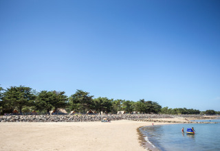 Strand met tenten en gezinnen bij Huttopia Noirmoutier, vakantiepark in Pays de la Loire, Frankrijk.