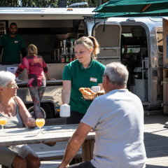 Frühstücksservice an einem Tisch vor einem Foodtruck im Huttopia Noirmoutier, Pays de la Loire, Frankreich.