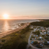 Sunset view of a beachside holiday park with caravans at Huttopia Ars-en-Ré, Nouvelle-Aquitaine, France.