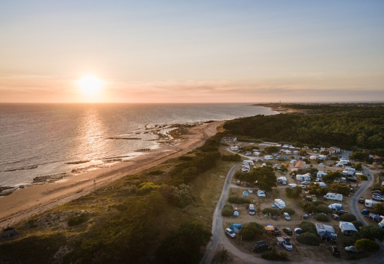 Solnedgang over en campingplads ved stranden på Huttopia Ars-en-Ré, Nouvelle-Aquitaine, Frankrig.