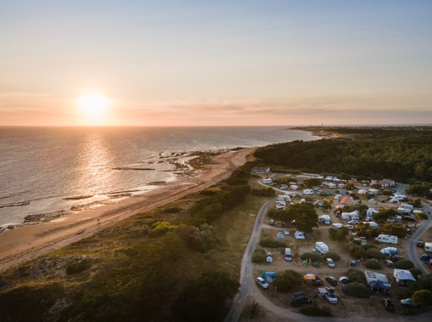 Zonsondergang boven een vakantiedorp aan het strand bij Huttopia Ars-en-Ré, Nouvelle-Aquitaine, Frankrijk.