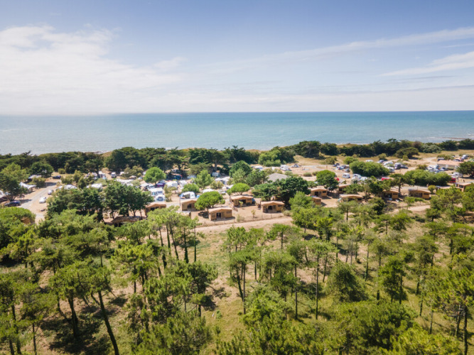 Aerial view of a campsite by the sea surrounded by trees near Ars-en-Ré, Nouvelle-Aquitaine, France.