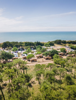 Vista aérea de un camping junto al mar rodeado de árboles cerca de Ars-en-Ré, Nouvelle-Aquitania, Francia.