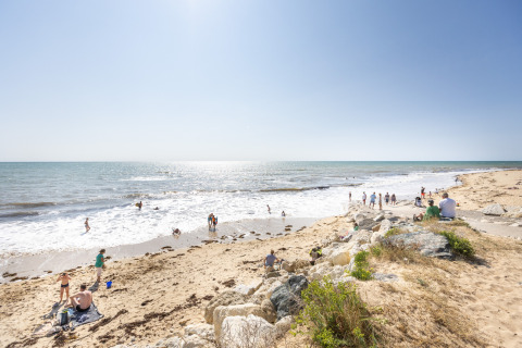 Personas disfrutan de un día soleado en la playa cerca de Ars-en-Ré, Nueva Aquitania, Francia, junto al mar.