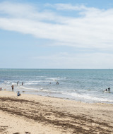 Playa cerca de Ars-en-Ré, Nouvelle-Aquitaine, Francia, con pocas personas disfrutando del mar y la arena.