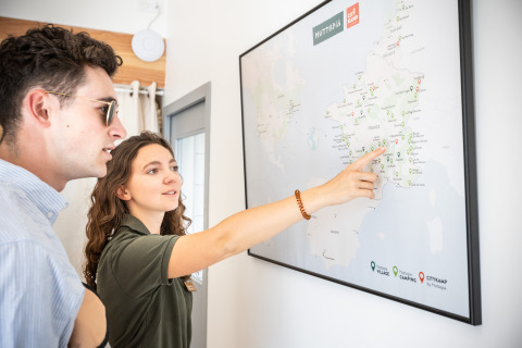 Dos personas mirando un mapa en el parque vacacional Huttopia Ars-en-Ré, Nouvelle-Aquitaine, Francia.