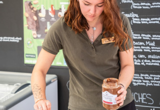 Een vrouw smeert chocoladepasta op een pannenkoek bij een eetstand in Huttopia Ars-en-Ré, Frankrijk.