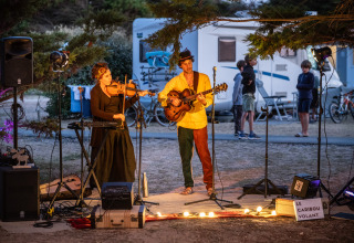 Muzikanten geven een avondoptreden in Huttopia Ars-en-Ré vakantiepark, Nouvelle-Aquitaine, Frankrijk.
