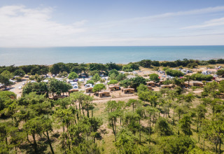 Udsigt over ferieparken Huttopia Ars-en-Ré i Nouvelle-Aquitaine, Frankrig, med hytter, telte og hav.