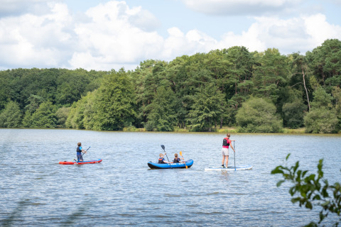 Mensen doen aan kajakken en paddleboarden op een meer nabij Sillé-le-Guillaume in Pays de la Loire, Frankrijk.