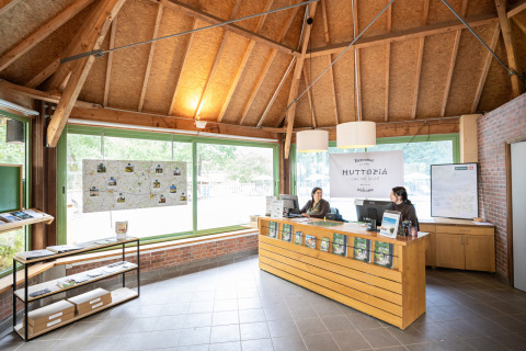 Receptie van Huttopia Lac de Sillé, een vakantiepark in Pays de la Loire, Frankrijk, met vriendelijk personeel.