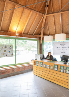 Recepción de Huttopia Lac de Sillé, un parque vacacional en Pays de la Loire, Francia, con personal atento.