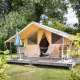 Safari Tent Classic med overdækket terrasse, stole og grønne omgivelser på en campingplads om sommeren.