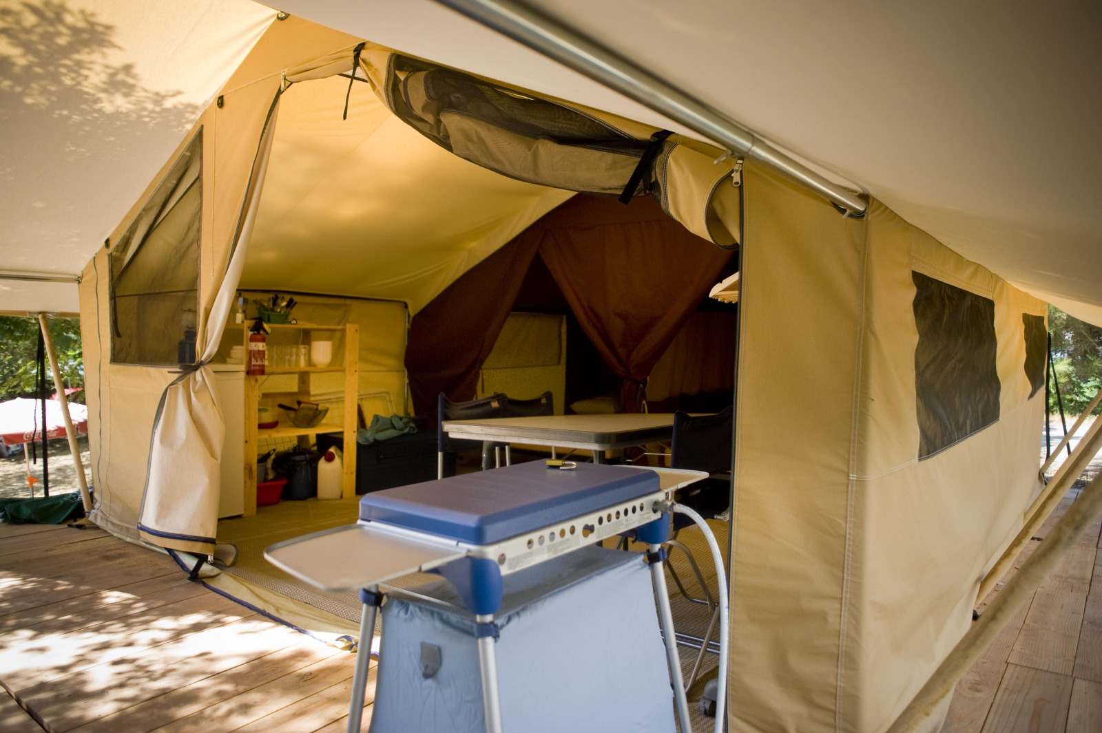 Interieur van de ruime Safari Tent Classic bij Huttopia Calvados - Normandie met keuken en eettafel.