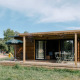 Chalet Portland set udefra, med terrasse, havemøbler, parasol og omkringliggende grønne områder.