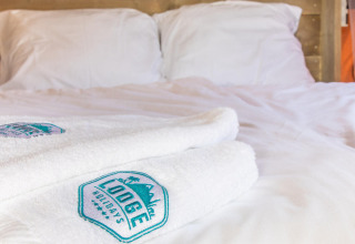 Cama de la tienda safari Base Lodge con toallas blancas en Boutique Camping Heart of Nature en Croacia.