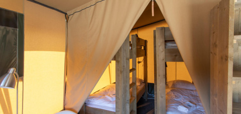 Vista interior de la tienda safari Base Lodge con literas en Boutique Camping Heart of Nature, Croacia.