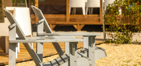 Zwei graue Holzliegen vor dem Base Lodge Safarizelt bei Boutique Camping Heart of Nature in Kroatien.