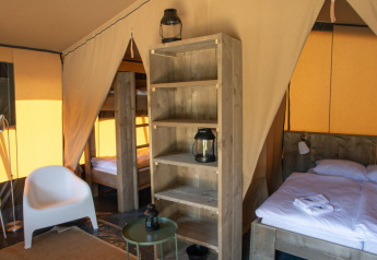 Vista interior de una tienda safari en Base Lodge, Boutique Camping Heart of Nature en Croacia, con cama doble.