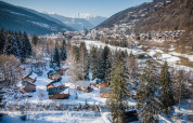 Winters zicht op Les Chalets Huttopia de Bozel, sneeuwbedekte chalets in Auvergne-Rhône-Alpes, Frankrijk.