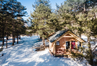 Holzhütte im verschneiten Wald bei Huttopia la Clarée, einem Ferienpark in Provence-Alpes-Côte d’Azur, Frankreich