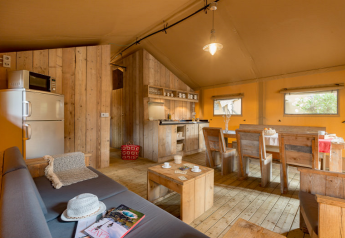 Innenraum des Safari-Zeltes Safari tent im Campo dei Fiori (Glamping4all) in Italien mit Holzmöbeln.