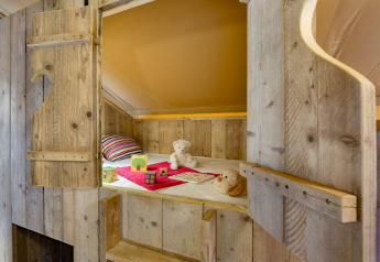 Gezellig houten stapelbed met speelgoed en knuffels in een safaritent bij Campo dei Fiori, Italië.